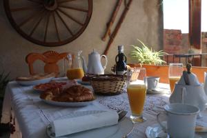 a table with a breakfast of croissants and orange juice at Casa rural tres regiones in Ontiñena