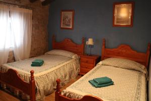 two beds in a bedroom with green towels on them at Casa rural tres regiones in Ontiñena +44 photos