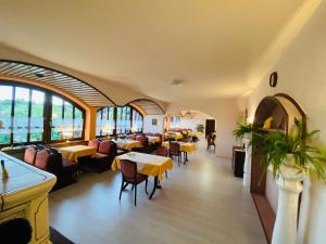 a restaurant with tables and chairs and windows at Pension Schmitt in Waldfenster