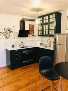 a kitchen with black cabinets and a stainless steel refrigerator at Mrongowiusza 3 in Olsztynek