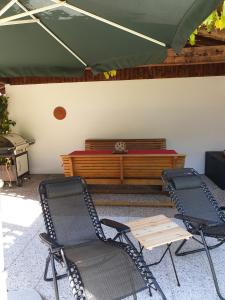 a patio with two chairs and a bench with a table at Ferienwohnung Alpenfex in Unterwössen