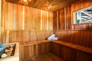 una sauna con paredes de madera y una ventana en Praia do Estaleiro Guest House, en Balneário Camboriú