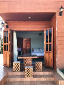 Casa de madera con mesa y cama en คอมคิม ริมโขง เชียงคาน, en Loei