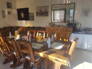 a wooden table and chairs in a living room at Aliwal Villa Guest Lodge in Aliwal North