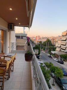 a balcony with tables and chairs and a view of a city at New luxury apartment in central suburb of Athens in Athens