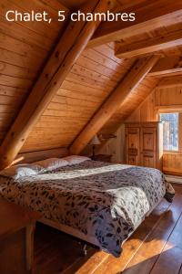 ein Schlafzimmer mit einem Bett im hölzernen Dachgeschoss in der Unterkunft Chalets et Spa Lac Saint-Jean in Chambord