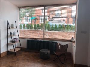 uma janela com um radiador e uma cadeira num quarto em Newly refurbished apartment in Chapel Allerton, Leeds em Moortown