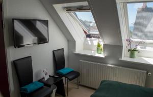 Cette petite chambre comprend 2 chaises et 2 fenêtres. dans l'établissement Samsø Perlen, à Sælvig