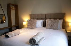 een slaapkamer met een bed met 2 opgerolde handdoeken bij The Berwick Inn in Polegate