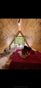 a room with a red bed in a wooden cabin at Bujtina Miqesia in Theth