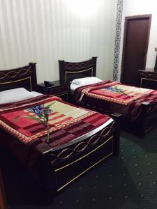 two beds sitting in a room at Royal palace hotel in Lahore