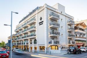 un edificio blanco con coches estacionados frente a él en Jo An Palace, en Rethymno