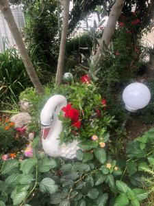 a garden with a statue of a swan and flowers at Apartmani Josipa in Šibenik