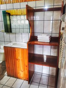 La salle de bains est pourvue d'un lavabo et d'une étagère avec des serviettes. dans l'établissement Hotel Don Taco, à Monteverde Costa Rica