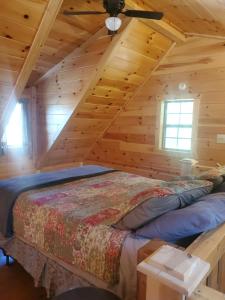 um quarto com uma cama num chalé de madeira em The Genoa - An Amish Built Deluxe Cabin em Genoa