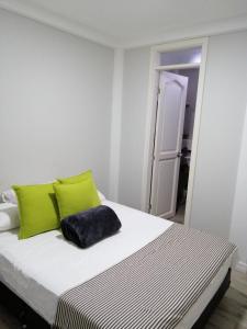 1 dormitorio con 1 cama con almohadas de color verde lima en Alicia Hostal Filandia, en Filandia