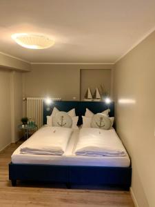 ein Schlafzimmer mit einem großen Bett mit weißer Bettwäsche und Kissen in der Unterkunft Haus am See in Möhnesee