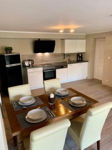 a kitchen with a wooden table and white chairs at Haus am See in Möhnesee