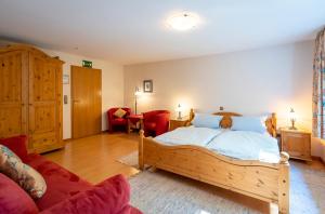 a bedroom with a wooden bed and a red couch at Zum Lindenbaum in Finnentrop