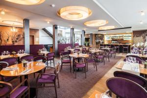 un restaurant avec des tables en bois et des chaises violettes dans l'établissement Hotel Aplaus, à Litomyšl