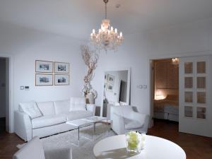 a living room with a white couch and a chandelier at Hotel Aplaus in Litomyšl