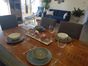 a wooden table with plates and wine glasses on it at Ferienwohnung Weizblick in Weiz