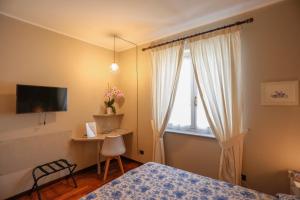 a bedroom with a bed and a desk and a window at B&B Ai Tre Cavalli in Cherasco