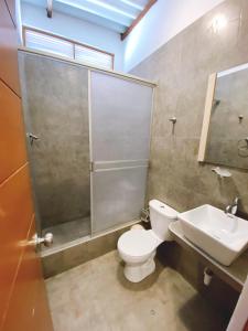 a bathroom with a shower and a toilet and a sink at Hotel Luna Nueva in Colán