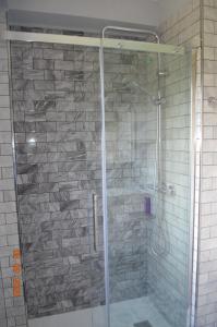 W łazience znajduje się prysznic ze szklanymi drzwiami. w obiekcie La Quintana del Castillo w mieście Soto del Barco