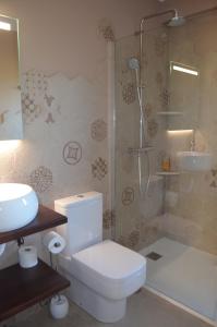uma casa de banho com um WC, um chuveiro e um lavatório. em La Quintana del Castillo em Soto del Barco