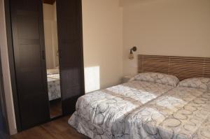 - une chambre avec un grand lit et un miroir dans l'établissement La Quintana del Castillo, à Soto del Barco