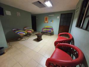 a waiting room with colorful chairs and a table at Hierba De Conejo Hostel in Oaxaca City