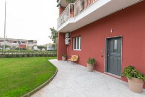 een rood gebouw met een deur en een patio bij Relax nel Verde in Segrate