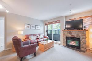 a living room with a couch and a fireplace at Deer Lodge by Outpost Whistler in Whistler