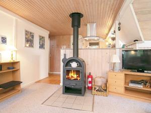 a fireplace in a living room with a tv at 6 person holiday home in Gedsted in Gedsted