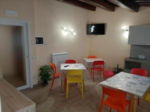 a dining room with tables and red and yellow chairs at Affittacamere Il Tiro a Segno in Norcia