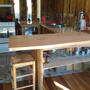 a wooden table in a kitchen with a counter top at Cabaña Cajón del Maipo in San José de Maipo