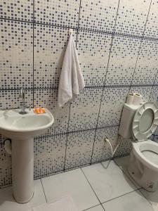 a bathroom with a toilet and a sink at FAMÍLIA CHARLEAUX in Aparecida +33 photos
