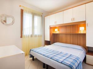 a bedroom with a bed and white cabinets at Belvilla by OYO Trilo 1 Solmare a Rosolina in Rosolina