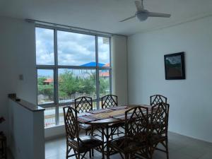 a dining room with a table and chairs and a window at Palmarito Beach Apartamentos in Carretal