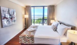 a bedroom with a bed with a view of the ocean at Cairns Plaza Hotel in Cairns