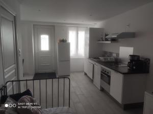 cocina con electrodomésticos blancos y puerta blanca en Little baie, en Pleine-Fougères