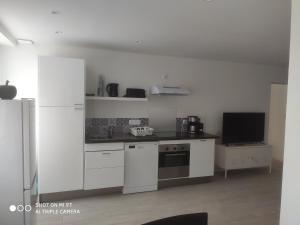 普萊訥富熱爾的住宿－Little baie，一间厨房,配有白色橱柜和一台电视机