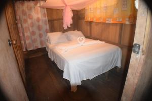 a small bedroom with a bed with a ribbon on it at Lodge Jungle Wolf Expeditions in Yucuruche