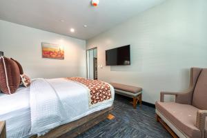 une chambre d'hôtel avec un lit et une chaise dans l'établissement Hotel Lexen Newhall & Santa Clarita - Near Six Flags Magic Mountain, à Santa Clarita