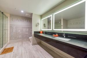 a bathroom with a sink and a large mirror at Hotel Lexen Newhall & Santa Clarita - Near Six Flags Magic Mountain in Santa Clarita