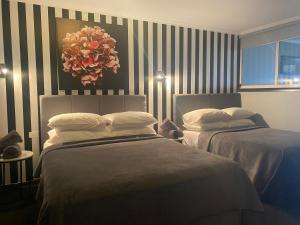 a bedroom with two beds and a vase of flowers on the wall at Waterside Holiday Rentals Unit 31 in Mulwala