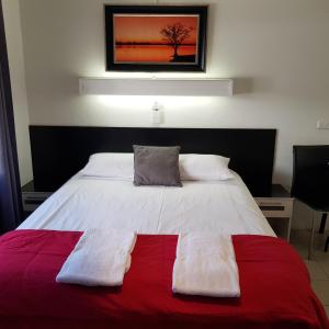 
a bed room with a white bedspread and a white comforter at Motel Lodge in Rockhampton

