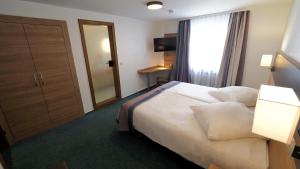 Postel nebo postele na pokoji v ubytování Hotel Goldener Hirsch Mosbach