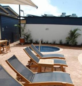 a group of lounge chairs next to a pool at Broadwater Mariner Resort in Geraldton